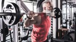 Older lifter at the safety squat station in the gym